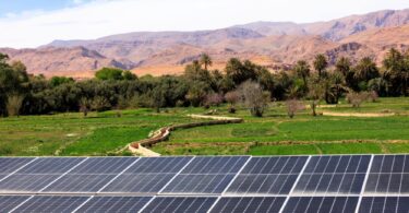 “Solar panels with farmland and mountains in the background, representing renewable energy and sustainable agriculture
