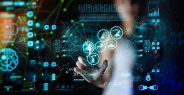 A person interacting with a digital interface displaying data visualisation, analytics icons and interconnected machinery graphics representing industrial monitoring technology.