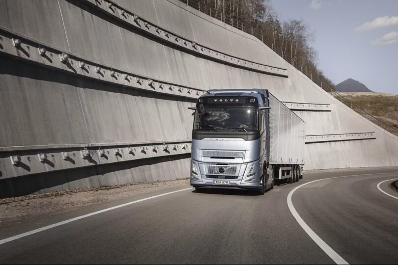 Volvo heavy-duty truck driving on highway demonstrating new stop/start fuel-saving technology.
