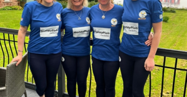 Four members of the Scotland the Wave rowing team standing together in matching blue shirts ahead of their Atlantic rowing challenge.