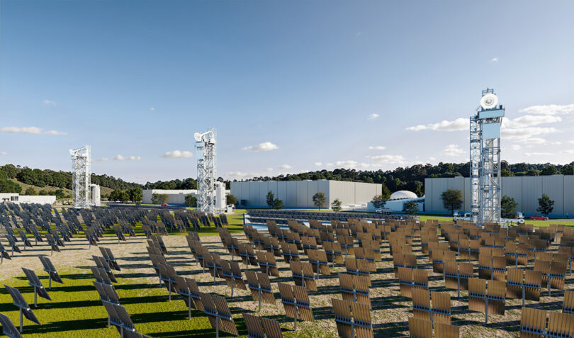 A solar-thermal facility with rows of solar collectors facing tall thermal energy towers at a 247Solar installation.