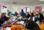 Amazon Filters volunteers sorting donated items at the Just4Kids children’s charity shop during a community volunteering day.