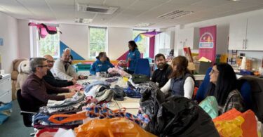 Amazon Filters volunteers sorting donated items at the Just4Kids children’s charity shop during a community volunteering day.