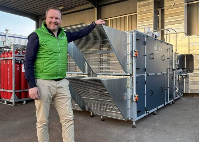 HYTING hydrogen hybrid heating system installation with CEO standing beside industrial air-heating unit