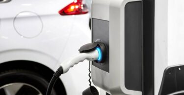 Electric vehicle market share in the UK with EV charging point connected to electric car