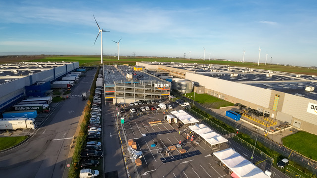 Aerial view of an Amazon fulfilment centre with wind turbines nearby