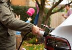 Driver charging an electric vehicle at home, representing the continued growth of electric vehicle adoption in the UK.