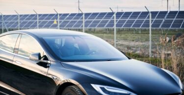 Electric vehicle parked beside a solar-powered charging station, representing the UK's growing transition to zero-emission transport.