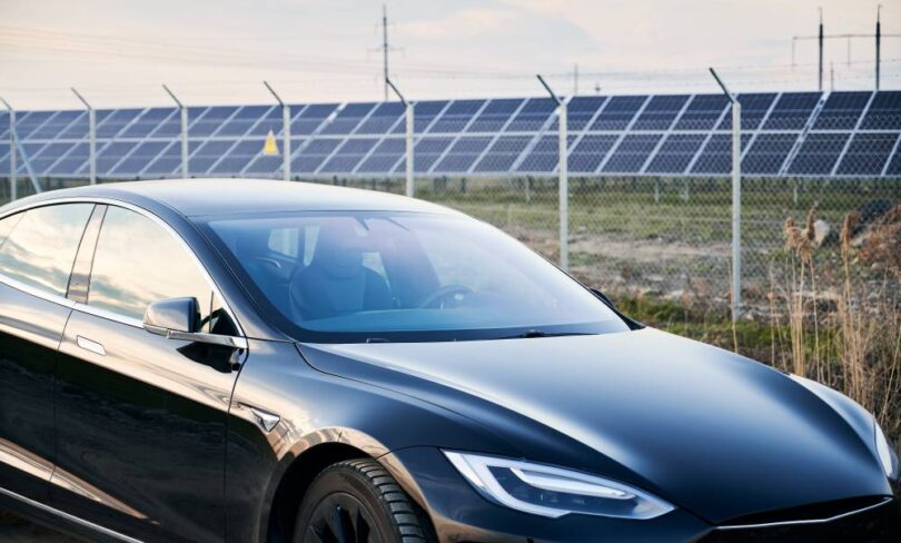 Electric vehicle parked beside a solar-powered charging station, representing the UK's growing transition to zero-emission transport.