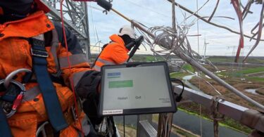 Technician testing CORECHECK technology on an overhead transmission conductor