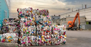 Bales of plastic waste stacked at an industrial recycling facility