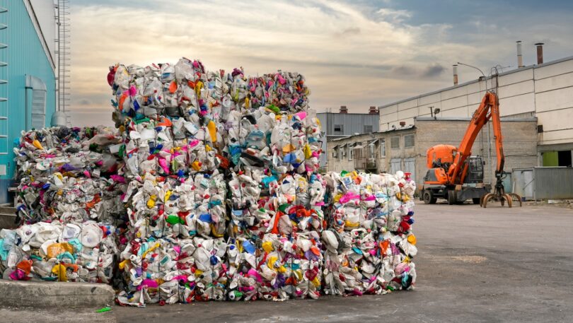 Bales of plastic waste stacked at an industrial recycling facility