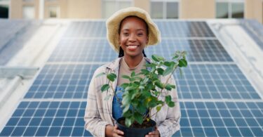 Woman standing in front of rooftop solar panels