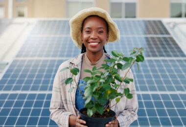 Woman standing in front of rooftop solar panels