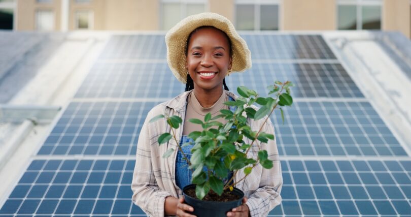 Woman standing in front of rooftop solar panels