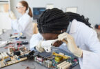 Portrait of a female engineer inspecting computer parts in a quality control lab.