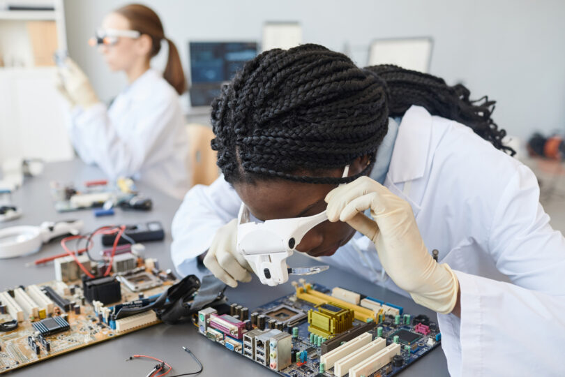 Portrait of a female engineer inspecting computer parts in a quality control lab.