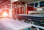 Workers assembling solar panels on a production line in a factory setting