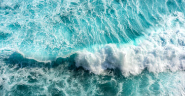 Turquoise and blue sea waves with white foam, as seen in Bali, Indonesia.