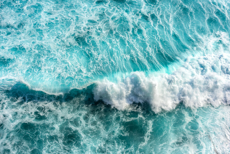 Turquoise and blue sea waves with white foam, as seen in Bali, Indonesia.